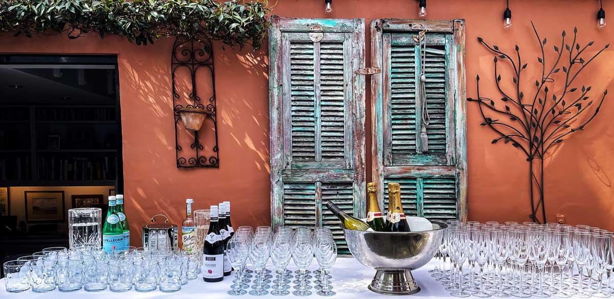 Bar set up with lots of glasses and booze in silver wine cooler.